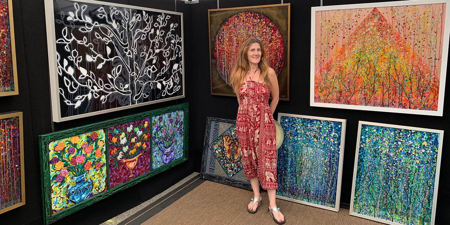 Rachel Shultz posing in her booth at a local art show